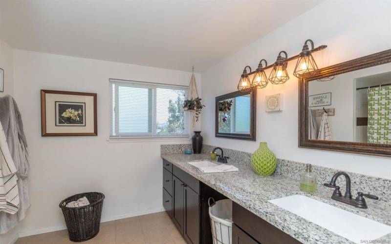 Remodeled master bathroom with dual sinks and mirrors with updated designer lighting