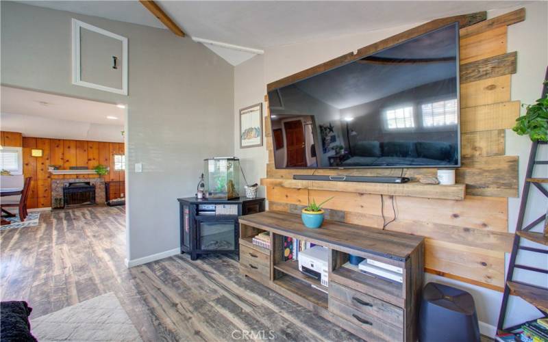 Mounted tv and storage access through upper cabinet in living room.