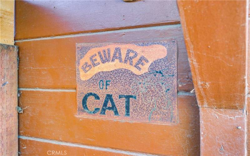 Antique signage displayed on the side of the workshop (by gate that leads to the garage).