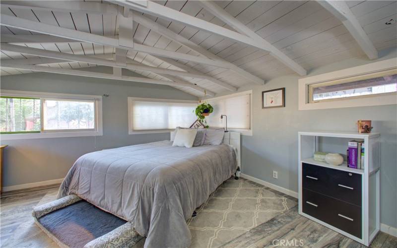 Master bedroom with wood-paneled ceilings.