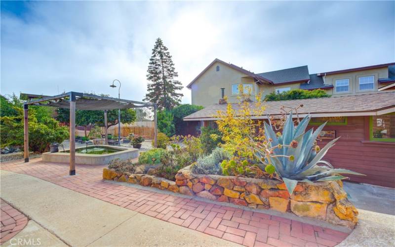 Concrete and red brick walkways in backyard.