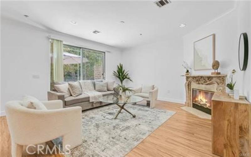 Living room with high ceiling & fireplace opens to the patio - perfect indoor / outdoor entertaining