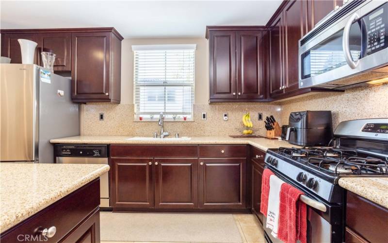 Gourmet kitchen with upgraded cabinetry, granite counter tops with full backsplash, large granite center island, stainless steel appliances