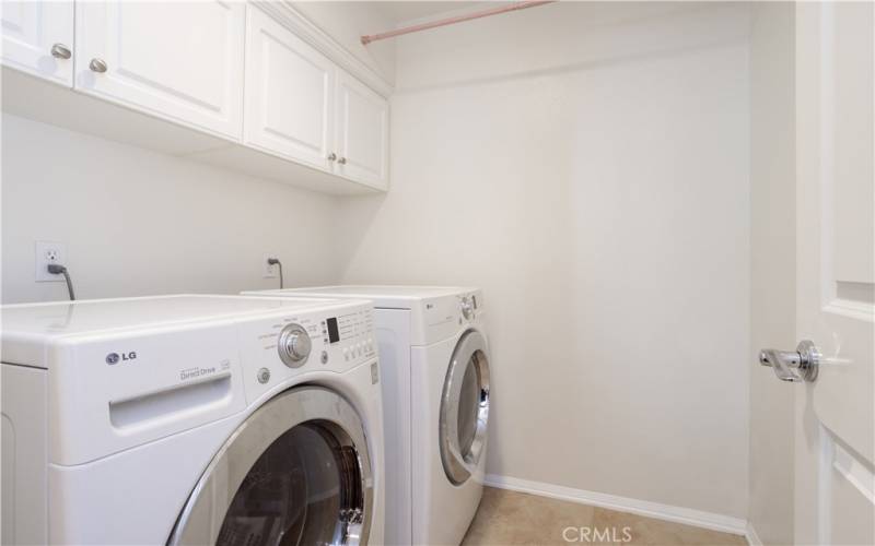 Private laundry room with side-by-side washer & dryer with extra cabinetry for storage