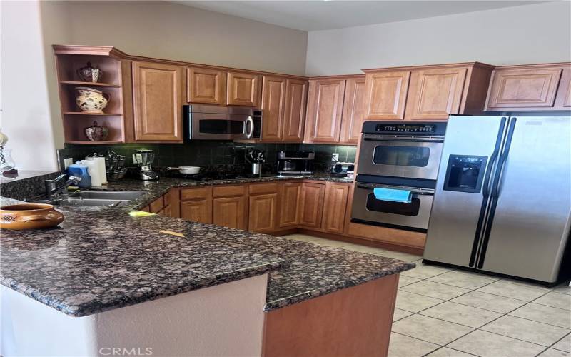 Opulent, open and fluidly functional kitchen with Stainless steel appliances.