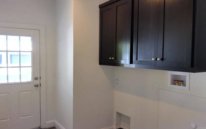 Laundry room features pretty door and cabinetry!