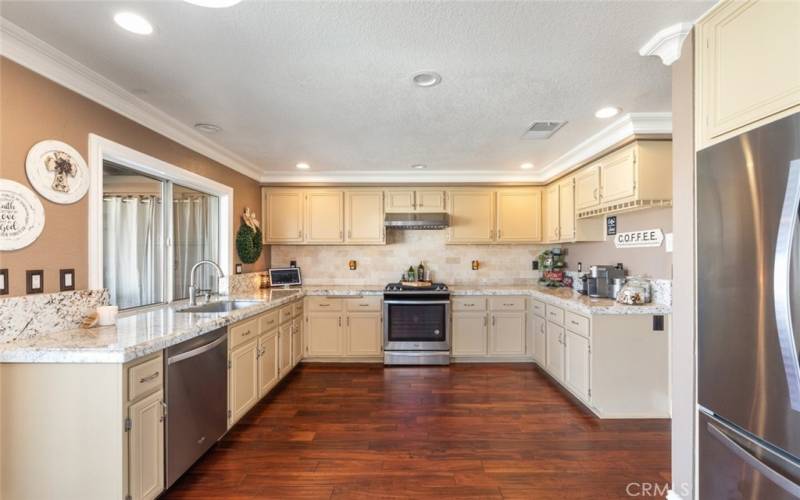 This bright and spacious kitchen features beautiful granite countertops, ample counter space, and sleek stainless steel appliances, perfect for any home chef.