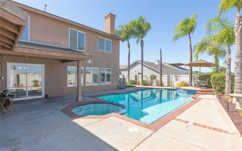 The backyard offers a refreshing pool and spa, complemented by a spacious covered patio, perfect for outdoor relaxation and entertaining.