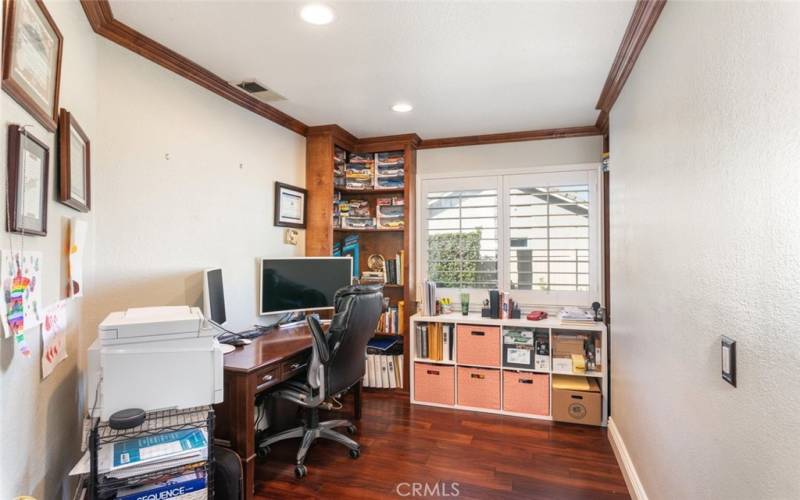 This cozy home office offers tons of storage, natural light, and a comfortable workspace, perfect for productivity and organization.