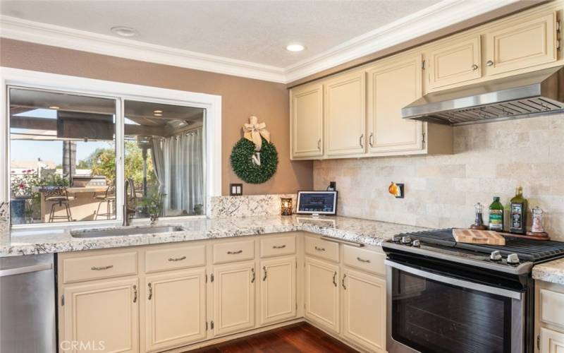 This bright and airy kitchen is filled with natural light, offering a lovely view of the outdoor patio through the large window.