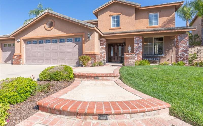 This charming home features a beautifully curved brick-accented walkway that leads to the inviting front porch and entrance.