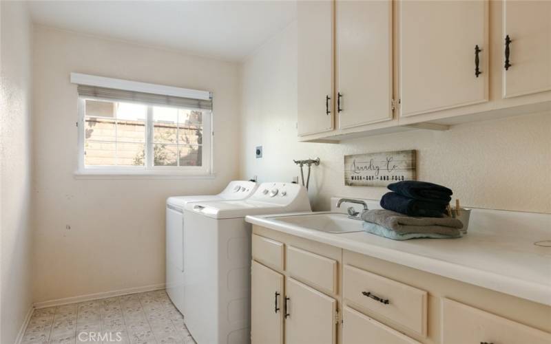 You will love an indoor laundry room with ample cupboard space and sink.