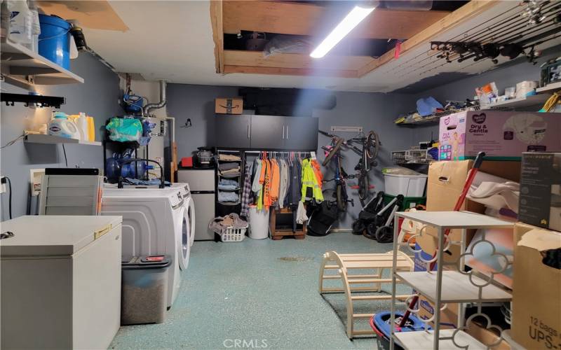 Laundry in finished garage with lots of storage above