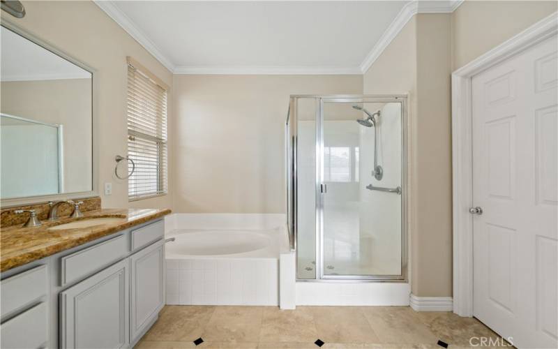 Travertine tiled floors in this generous master bathroom.