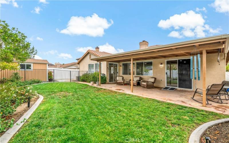 Grassy area connects to a separated side yard with large shed.