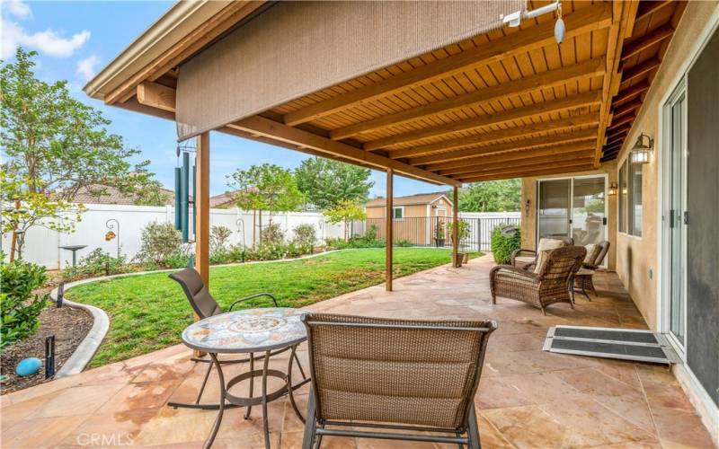 Backyard with tiled patio and solid wood cover.