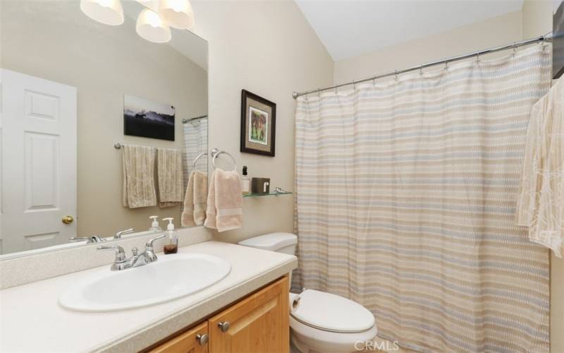 The hall guest bath has tile floors and tub with shower over.