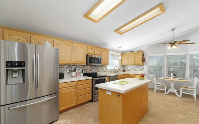 Look at this extraordinary kitchen with stainless steel appliances, custom tiled backsplashes, cabinets galore, pull-out shelves at the island and pantry.