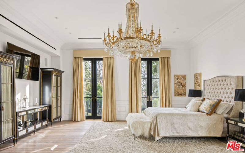 Elegant primary bedroom with ultra high ceilings facing south