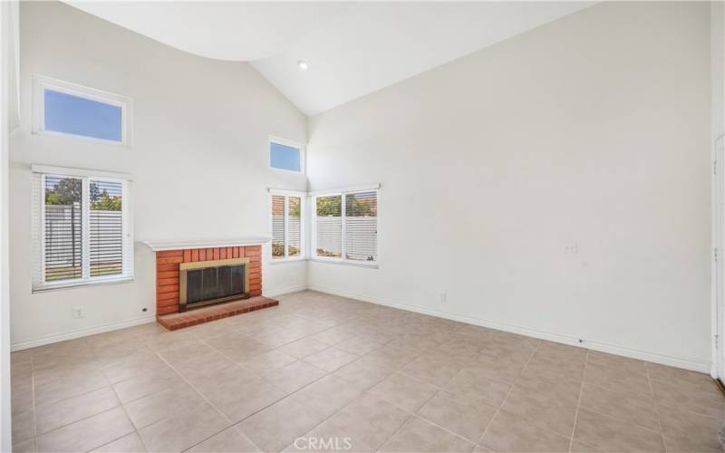 Living room with vaulted ceilings and fireplace.