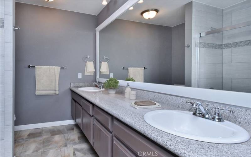 bathroom with double sinks, shower with tub