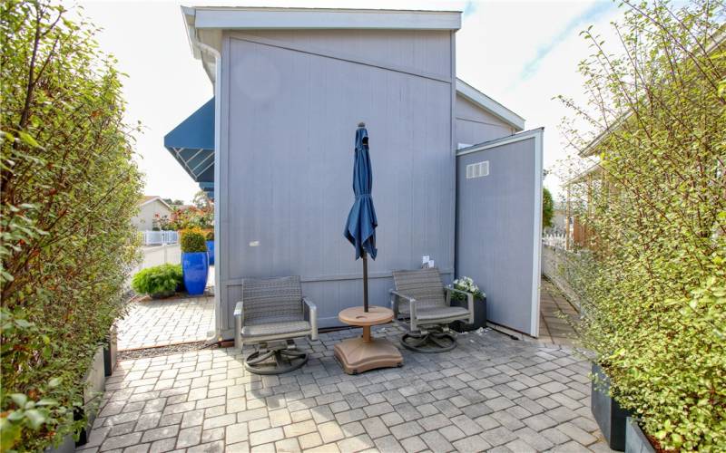 Secluded patio tucked in back corner with privacy shrubbery in planter boxes.