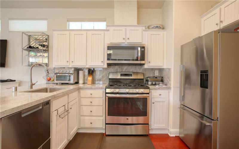 Top of the line stainless appliances include Fisher & Paykel refrigerator and two drawer dishwasher, GE 5 burner gas range with grill, Stainless farmhouse sink and quartz counters.