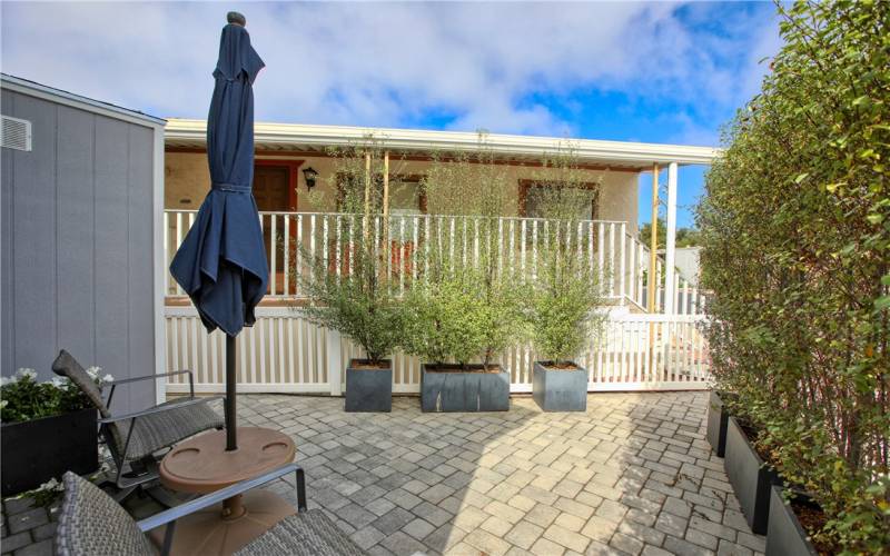 Secluded patio tucked in back corner with privacy shrubbery in planter boxes.