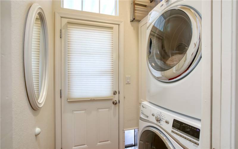 Laundry room with exterior door to patio and carport. Stacking washer and gas dryer are included.