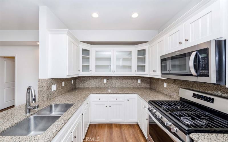 Kitchen features granite countertops, stainless steel sinks and appliances, undercabinet lighting,