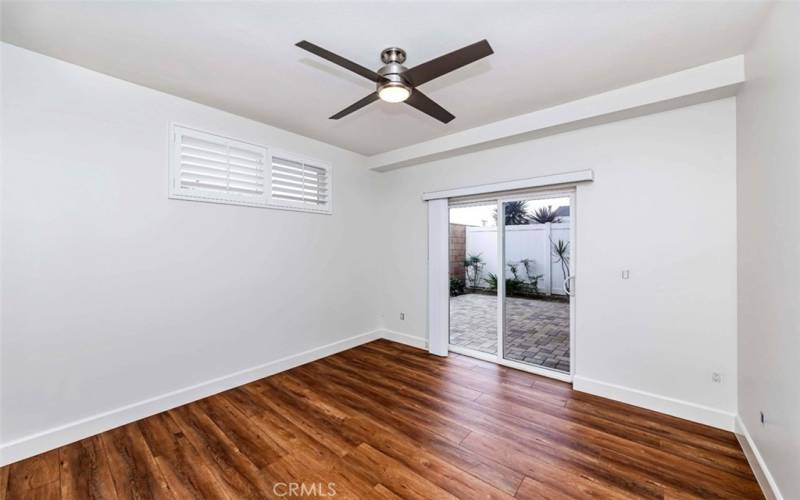 Downstairs bedroom opens out to a paved patio area.