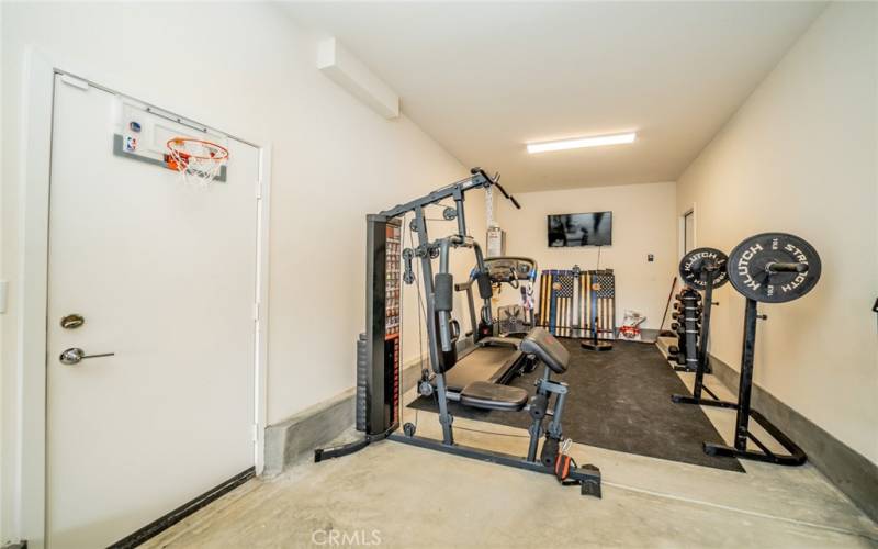 3 car tandem garage. an area is used as a gym.