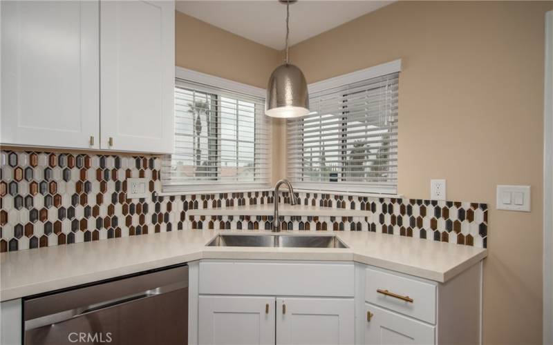 Kitchen sink area with window and dishwasher