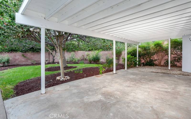 The exquisitely landscaped backyard will be a favorite entertainment destination with its large covered patio with lighting, green lawn, manicured flowerbeds, raised garden beds, mature shade trees, vintage David Austin roses, and gated RV access and parking.