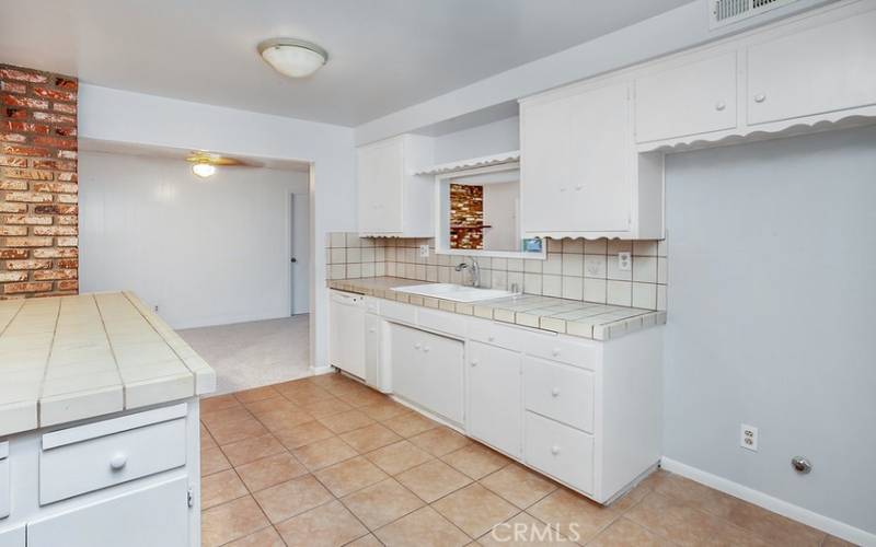 The cook in the family is going to truly appreciate the open and bright kitchen with its gleaming window, white cabinetry, handy pantry, tile countertops, dual basin sink, GE dishwasher and easy-care tile floors; plus, a convenient breakfast bar.