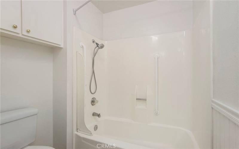 Primary Bathroom with toilet, tub/shower and storage