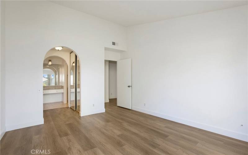 Primary Bedroom with arched entry to dressing / vanity area