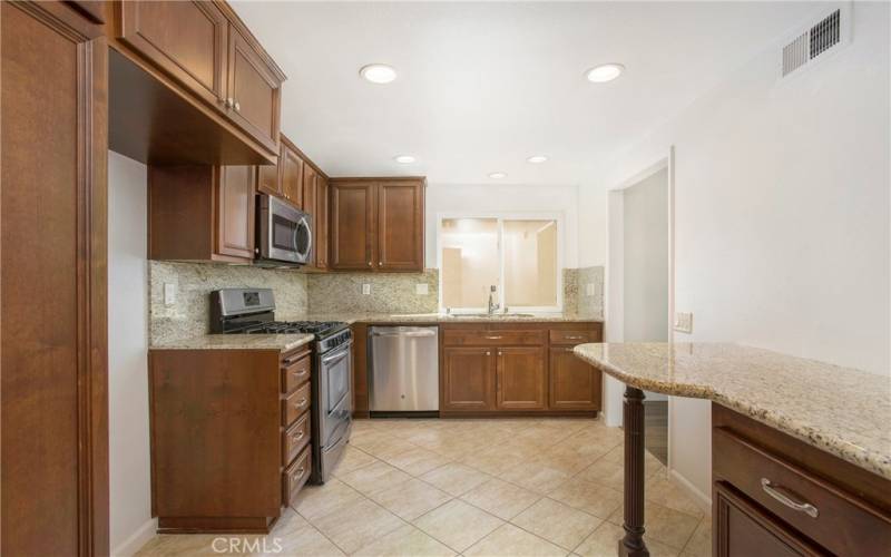 Kitchen with newer cabinets, Gas Stove, Granite Counters, Tile Flooring, Recessed Lighting, Window with over looking side patio area