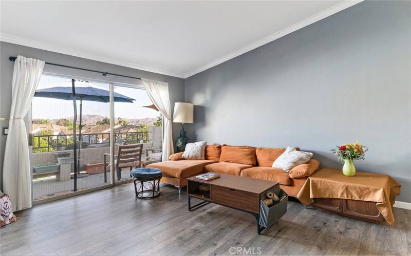 Living room with sliding glass doors to balcony, mountain views