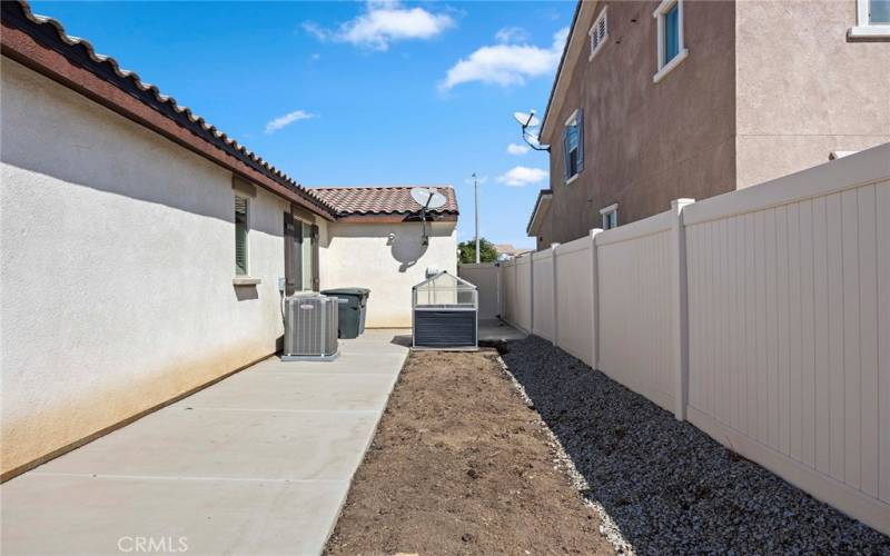 Side yard with raised garden bed.