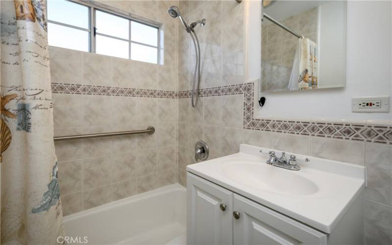 Full bath with updated tile and vanity, plus grab bars