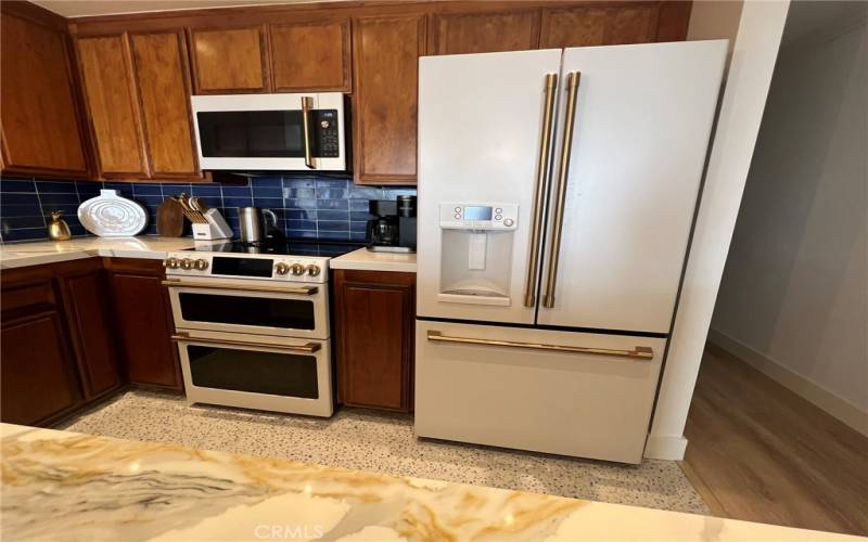 New White Cafe appliances with vibrant gold hardware