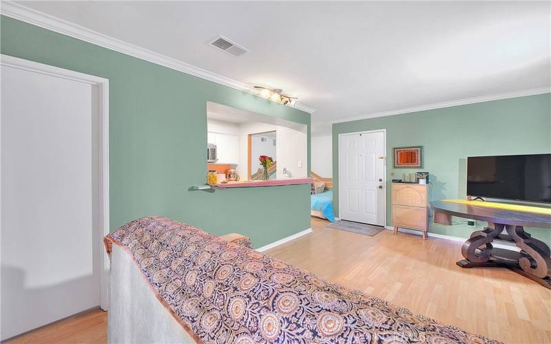 Living room has beautiful crown moldings and laminate flooring.