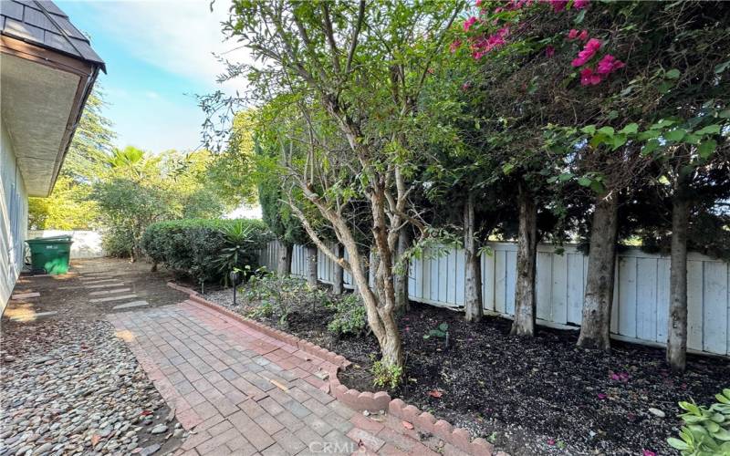 Large side yard that opens to the front yard with wooden fencing.