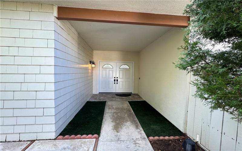 Synthetic grass and new paver tiles in front entry.