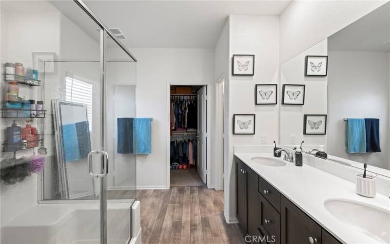 Main bathroom with double sinks and attached walk-in closet.