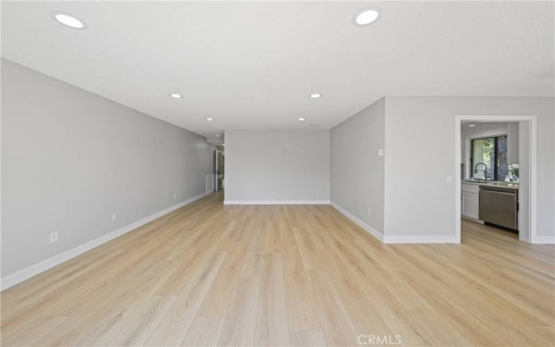 living room facing front entrance, galley kitchen with dishwasher and sink