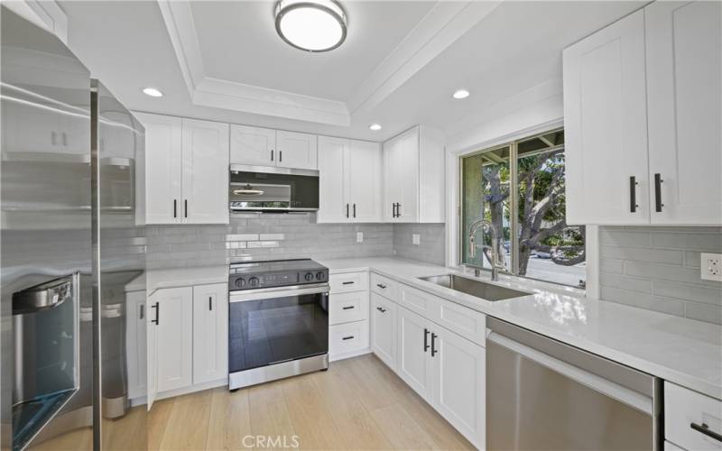 galley kitchen with new appliances, shaker cabinets, quartz counter top