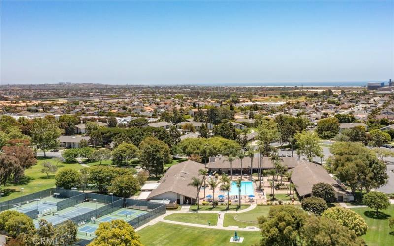 Drone shot of pool, club house, recreation rooms, tennis courts, putting green with Pacific Ocean 1.5 miles west.