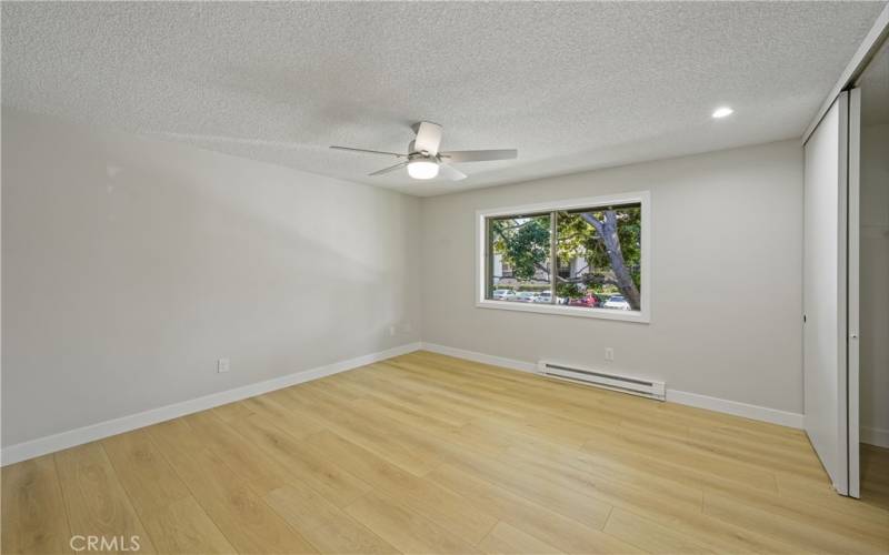 primary only bedroom, heating unit on base board, ceiling fan and closet